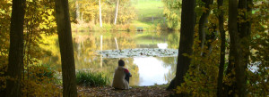 Woman sitting by lake